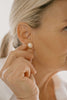 Close-up of a person wearing a pearl earring.