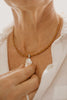 close up of a person wearing freshwater pearl and leather necklace