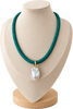 A teal green braided cord necklace with a large, irregular white baroque pearl pendant and a small gold clasp, displayed on a beige fabric jewelry bust.