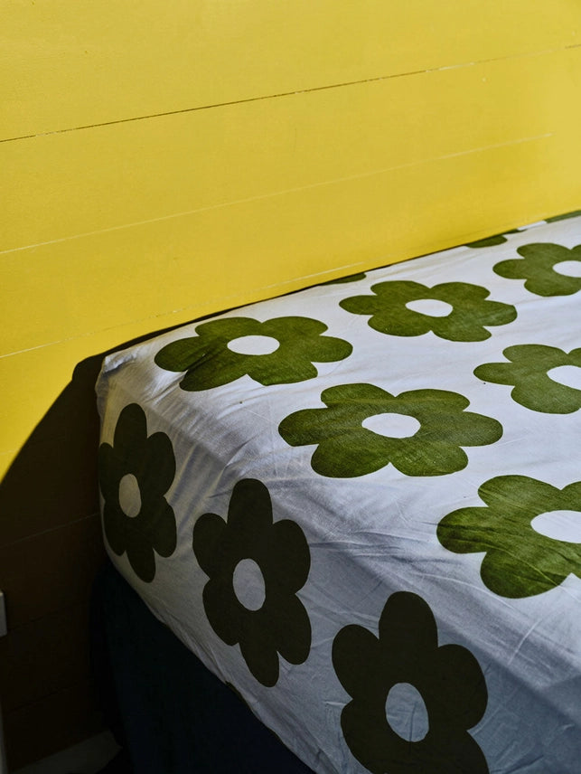 his fitted sheet in our Flowerbed print is a bold, playful pattern that pairs well with our Flowerbed bedding or solid colour bedlinens. It features a cornflower blue base with graphic floral pattern in khaki green. 